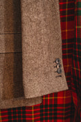 Load image into Gallery viewer, Close-up of textured fabric with a herringbone pattern and a button, alongside a plaid pattern.
